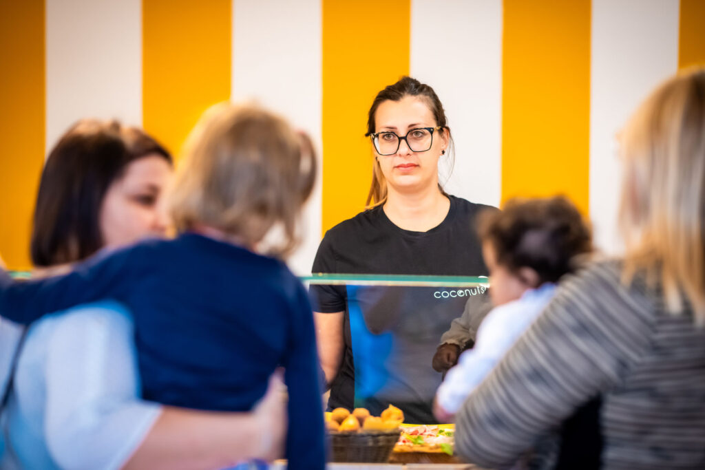 Licia al bancone con due clienti della Pizzeria Coconuts gluten free.